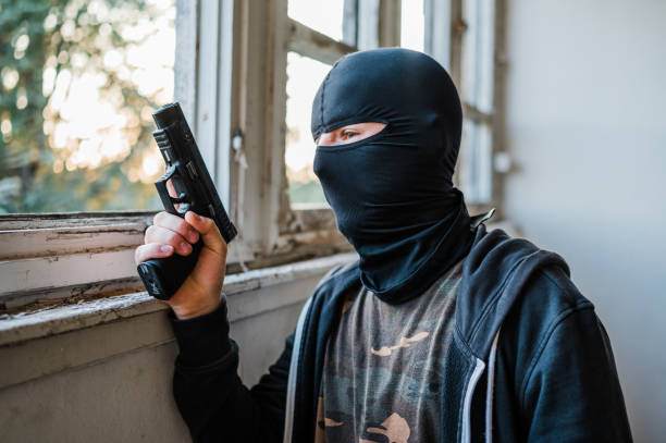 Criminal, thief, robber guy with a handgun.